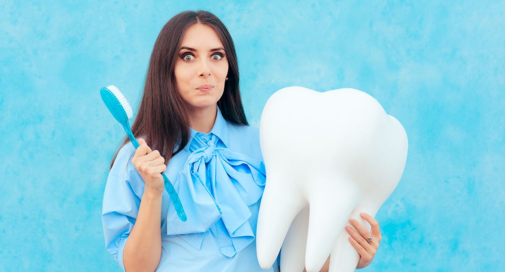 Funny,Woman,Holding,Oversized,Tooth,In,Dentist,Concept,Image.,Cute