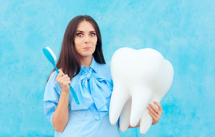 Funny,Woman,Holding,Oversized,Tooth,In,Dentist,Concept,Image.,Cute