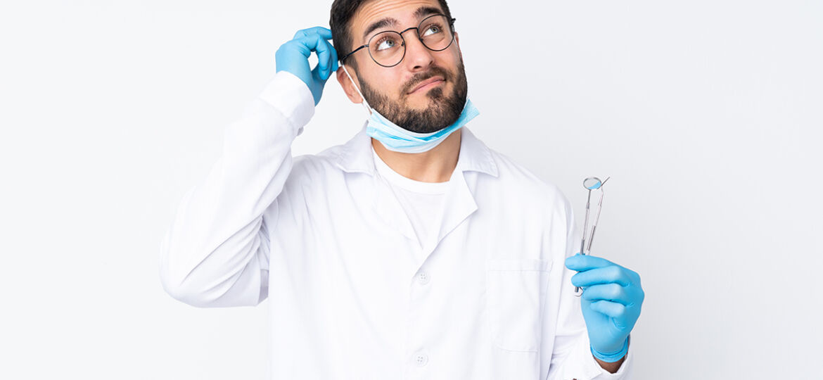 Dentist,Man,Holding,Tools,Isolated,On,White,Background,Having,Doubts
